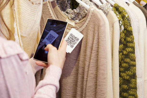Woman scanning a QR code, with her smart phone, from a label in a clothing store. 